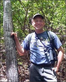 Photo by the Georgia Department of Natural Resources, Nathan Klaus, a senior wildlife biologist with the Georgia Department of Natural Resources, stands beside a rare American chestnut tree he spotted in Georgia