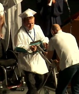 disabled student walks to graduate