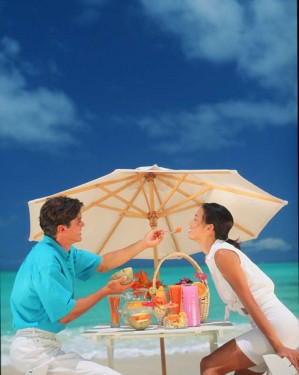couple-under-beach-umbrella-eating-sunstar