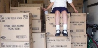 schoolgirl-atop-cartons-green-products.jpg