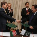 Pakistan and Afghan trade reps signing as Hillary looks on