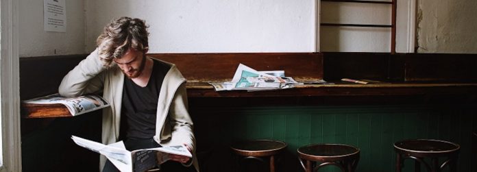 youth man-reading-newspaper alone