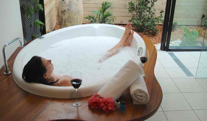 Woman Sleeping in Bathtub With Wine-CC Witches Falls Cottages via FLickr