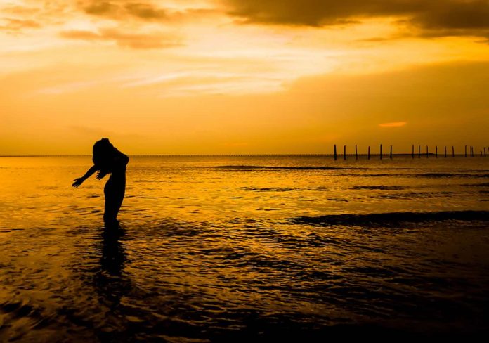 victory woman confident in ocean water-silouette-sunrise-pubdomain-Slava B