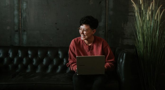 woman on the courch on laptop smiling-pubdomain-Brooke Cagle