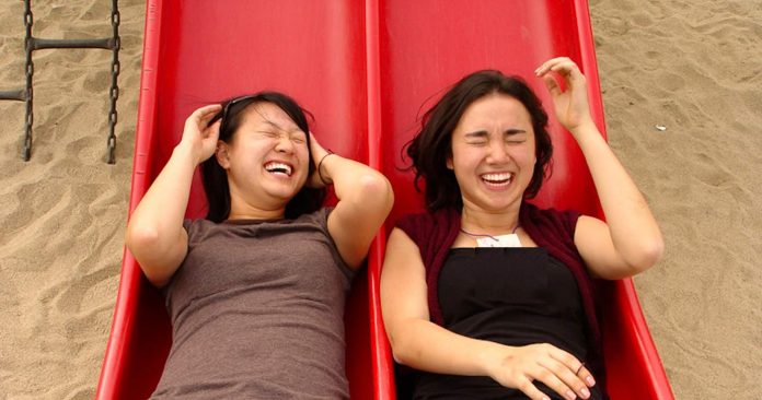 2 women sisters on slide-playground-fun-laughing-cc-Wesley Chan