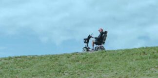 Man in a wheelchair on grassy terrain