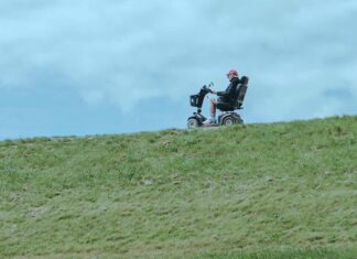 Man in a wheelchair on grassy terrain