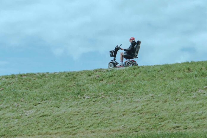 man in wheelchair on terrain challenge overcoming limits-pubdomain-britt gaiser Man in a wheelchair on grassy terrain