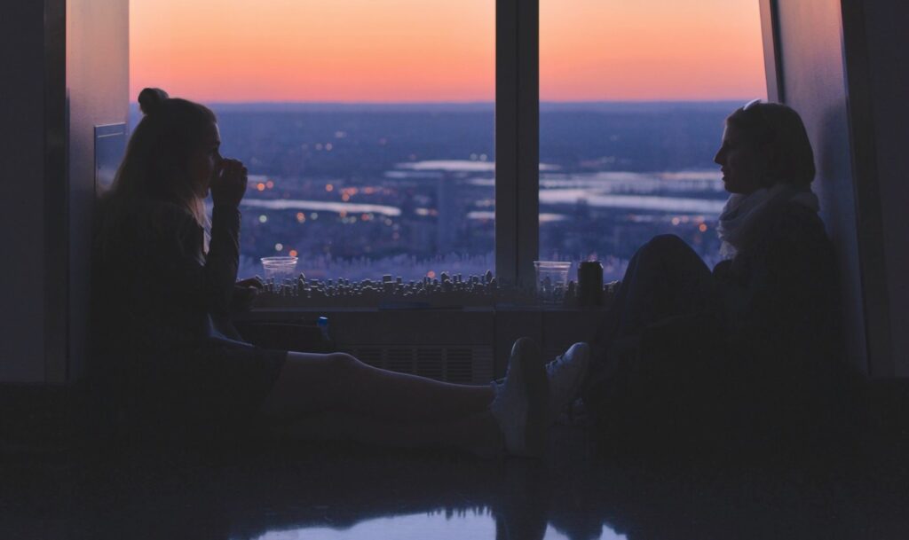 girlfriends talking in window