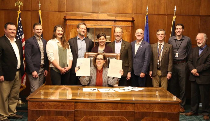 Oregon Governor Kate Brown signs bills in 2019-posted to Flickr-CC