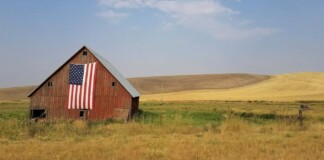 old barn with american flag and Midwestern crops