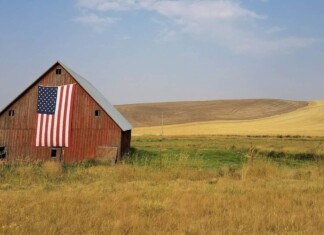 old barn with american flag and Midwestern crops