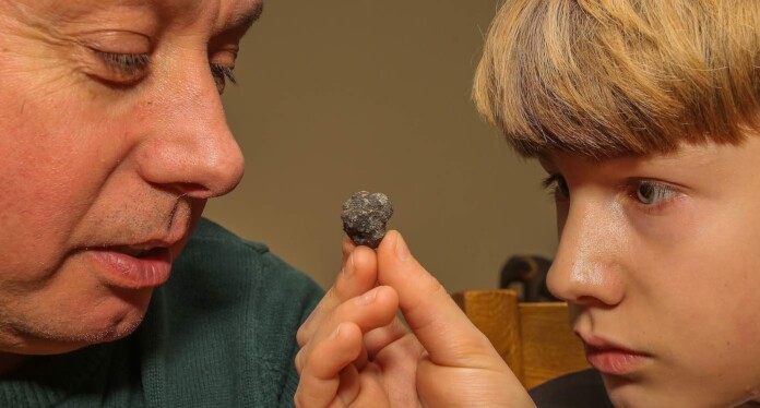 Paul Butler with son Nathan and suspected meteorite rock-SWNS