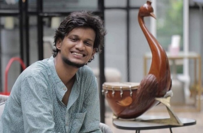 Tharun Sekar working with Yazh behind him - credit Uru Instruments