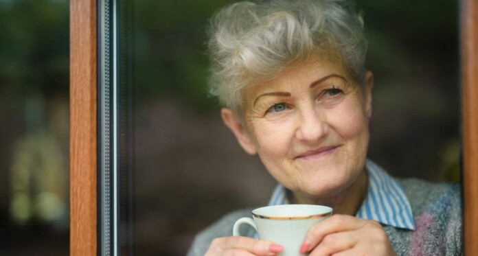 Aging senior happy woman w coffee at window by Getty Images For Unsplash+ tqH-8IspzgE