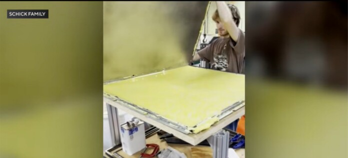 Young Nick Schick takes a large plastic sheet off a mold - credit, family photo submitted to CBS